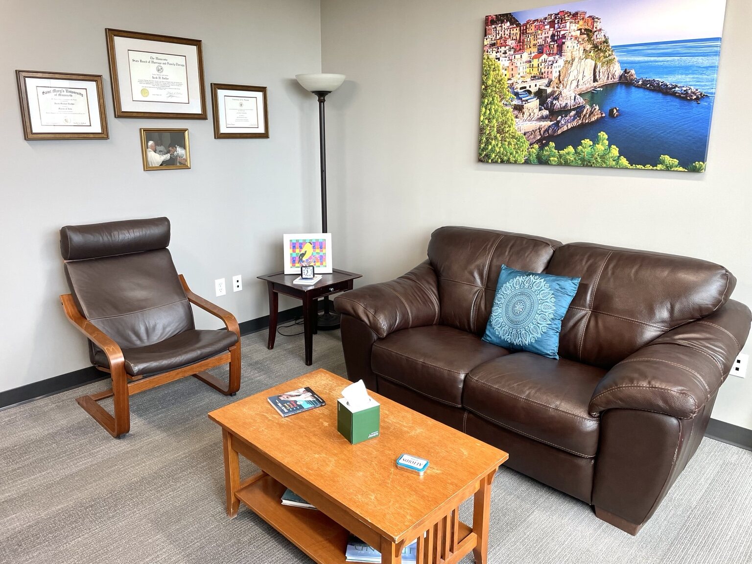 Jake's therapy office with a couch, chair, artwork, and coffee table